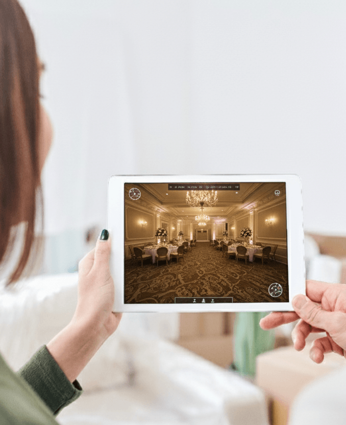 Pareja sonriente explorando un recorrido 360° virtual de un salón de fiestas en una tableta, mostrando la facilidad de una visita virtual a un espacio de eventos en Ciudad de México.