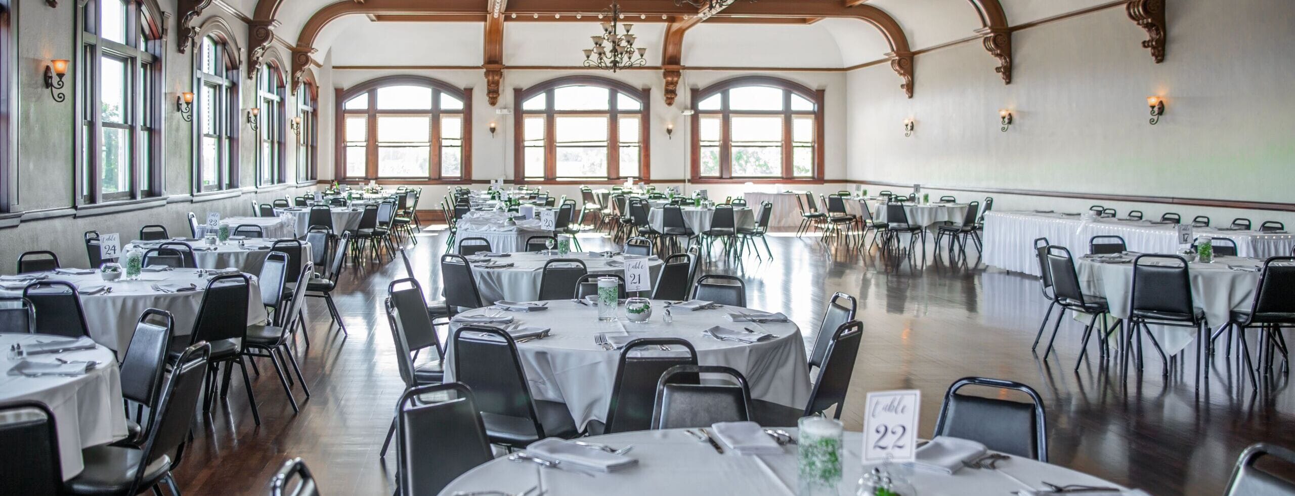 Salón de eventos adornado con luces cálidas, mesas listas y decoración elegante para una boda o fiesta en Ciudad de México.